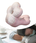 Woman napping at a desk with a Go-To Travel Napping Pillow with Face Cradle, ergonomic pink pillow, 25x25x30 cm.