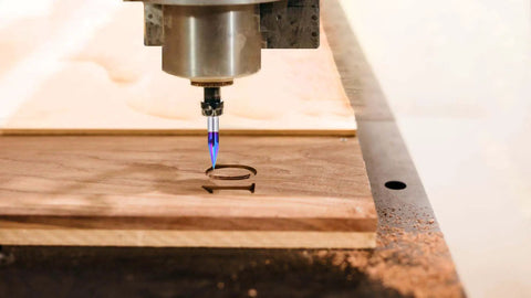 Close-up of One Quarter Inch Shank 30 Degree V Groove Engraving Bit, 3 Flute Solid Carbide CNC Router Bit with blue NACO coating in action.