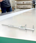 Micpointik Digital Caliper 6 Inch measuring metal sheet with LCD readout in a workshop setting.