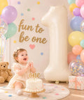 Giant Forty Inch Beige Mylar Foil Number 1 Balloon With Straw For First Birthday And Age Milestone Party Decorations, with cake and child.