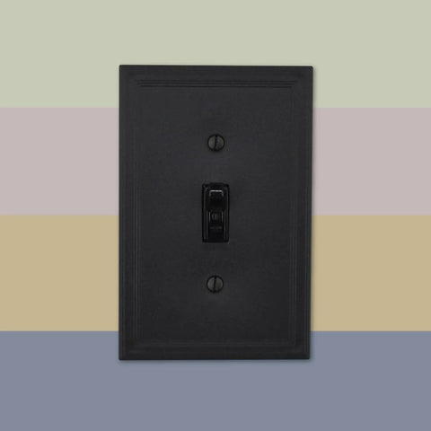 Black single switch plate on colorful striped background