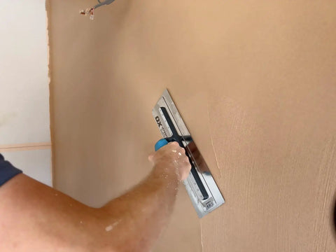 Person using UltraFlex Pro Finishing Trowel 14 Inch 355 X 110 Mm for smooth plaster on wall, comfort grip handle visible