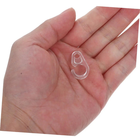 Holding a single transparent hook from 40 Pack Plastic Curtain Hooks For Doors And Curtain Rods With Silent Glide No Fuss Easy Hanging For Home