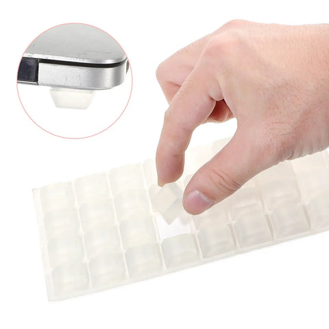 Hand holding a clear rubber bumper from a 32 pack of Thirty Two Piece Clear Rubber Bumpers Super Sticky Self Adhesive Pad.