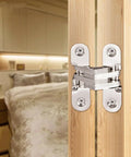 Concealed Cross Hinges Set Of Two In 304 Stainless Steel installed on wooden door in upscale kitchen or club setting.
