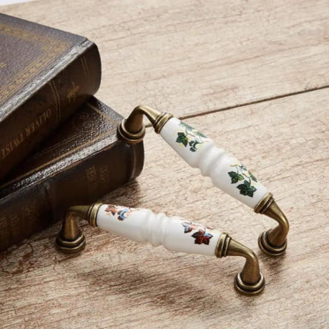 10 Pack Vintage Ceramic Cabinet Pulls Featuring Hella Charming Red Floral Motifs On Creamy White Porcelain Base Coupled With Antique Bronze Zinc Alloy Hardware For Authentic French Country Kitchen Cabinets Drawers And Furniture 96mm Hole Centers on rustic wooden surface