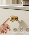 Premium Zinc Alloy Cabinet Knobs And Drawer Pulls One Inch Round Ball Champagne Bronze Finish close-up with finger touch on cabinet drawer.