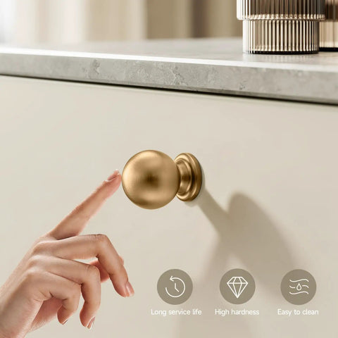 Solid Core Zinc Alloy Cabinet Knobs 1 Inch Round Ball Drawer Pulls In Champagne Bronze Finish, finger touching knob.