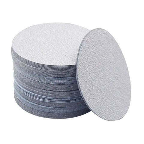 Grab This Awesome 100 Piece Set Of 5 Inch Wet Dry Sanding Discs With Grit From 60 To 1000 For Serious Polishing And Grinding Jobs Without Wasting Time Or Clogging Up Your Gear So You Can Get That Smooth Finish Fast. Stack of grey 5 inch sanding discs.