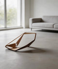 Modern wooden decorative object displayed in a minimalist living room with a grey couch.