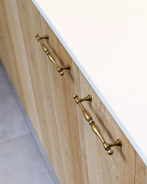 Six Pack Antique Brass Cabinet Pulls With 7.6 Inch Hole Center installed on wood cabinet drawers.