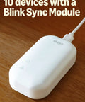 Level Up Your Home Security Game With This Black Outdoor Wireless Camera delivering a white Blink Sync Module for device connectivity.