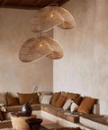 YAXDQUW Irregular Shaped Rattan Pendant Light Hand Woven Wicker Hanging Ceiling Lamp Adjustable Cord in cozy living room setting.