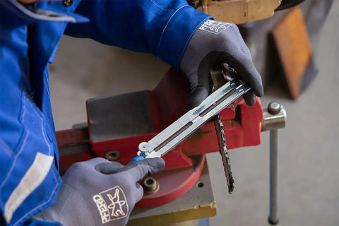 Person using Chainsaw Sharpening Files Set CS SLS 4.0 In Roll Bag, 4 mm Diameter, on chainsaw chain mounted in vice.