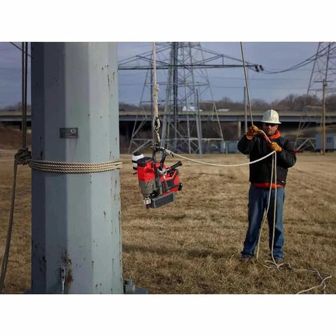 Milwaukee M18 1-75 Inch Cordless Magnetic Drill Press Kit With 5.0 Ah Battery And Charger suspended from a pole on a construction site.