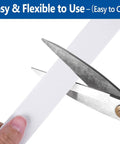 Heavy Duty Self Adhesive Foam Weather Stripping Tape For Doors And Windows Square Black Draft Buster being cut with scissors.
