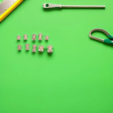 500 Piece Brass Knurled Threaded Nut Insert Kit For Mechanical And DIY Projects Pro Grade Sturdy Brass Embedding Nuts That Prevent Loosening Compatible With Plastic And Metal Parts Organized Storage Case brass inserts laid out with measuring tools