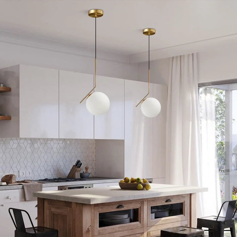 Mid Century Modern 1 Light Globe Pendant Chandelier In Brushed Gold With White Glass Ball For Kitchen Island Industrial Retro Style Single Pendant Light Fixture displayed in a modern kitchen setting.