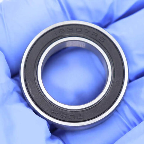 Close-up of Sealed Cartridge Bearing Set 18 X 30 X 7 mm MR18307 RS 5 Pack For Bike Hubs With LBlu Seals, held with gloves