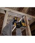 Close-up of hands using a Compact 20V Max Brushless Cordless Hammer Drill with ratcheting chuck for overhead drilling.