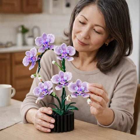 Woman assembling Purple Orchid Building Block Set With Vase, 619 Pieces, Phalaenopsis Floral Model Kit, Compatible With Lego Flowers.