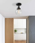 Slick Modern Semi Flush Mount Ceiling Light With Handblown Clear Glass Globe Shade in hallway, black finish, E26 LED compatible.