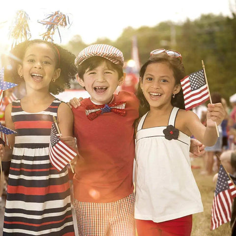 Children holding 25 Pack Small American Flags On 12 Inch Wooden Sticks With Antique Bronze Spear Top 5x8 Inch at outdoor event