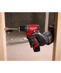 Hand using Subcompact Brushless 3/8 Inch Drill Driver Kit for Tight Spaces on wood, showing torque and power.