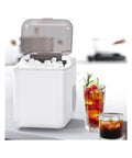 Fast Countertop Ice Maker Portable With Self Cleaning Setup Produces Crisp Cubes In Minutes, filled with ice, beside drinks.
