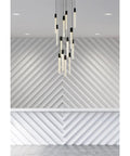 Slick Modern 13 Light Black Crystal Ceiling Pendant with Heavy Duty Metal Build illuminating a stylish geometric wall.