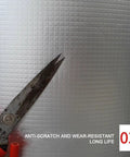 Super Sticky High Density Acoustic Foam Wall Panels With Built In Aluminum Foil, showing scissors cutting the textured material.