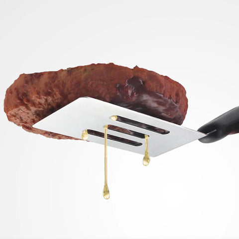 Mini stainless steel slotted spatula with black handle lifting a brownie.