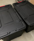 Set Of 2 40 Gallon Industrial Tote Bins With Wheels Heavy Duty Plastic Storage Containers with red latches and drip resistant lids.