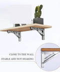 Heavy Duty Rock Solid Folding Wall Mount Shelf Brackets Crafted From Premium Stainless Steel With A Durable Matte Black Coating, displaying stable shelf setup with cactus.