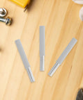 Smooth As Butter Soft Close Dampers For Trash Cans And Cabinet Doors 6 Pack showing grey ABS housing pieces on a wood surface.