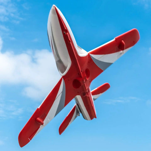 Red 50mm EDF Jet RC Plane for Adults, flying outdoors, showcasing underside and wings, with Vector Flight Stabilization System.