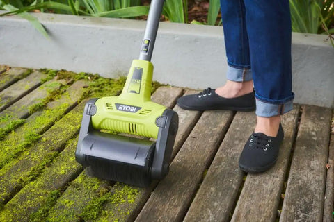 Cordless 18 Volt Patio Surface Cleaner With Telescoping Handle being used to scrub moss off wood deck.
