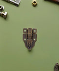12 Pack Antique Metal Toggle Latches For Cabinets, Suitcases, Wood Chests, Jewelry Boxes, Decor Trunks And Treasure Locks Heavy Duty Hasp Catches That Look Totally Cool And Get The Job Done Real Nice. Antique metal toggle latch on green surface, front view
