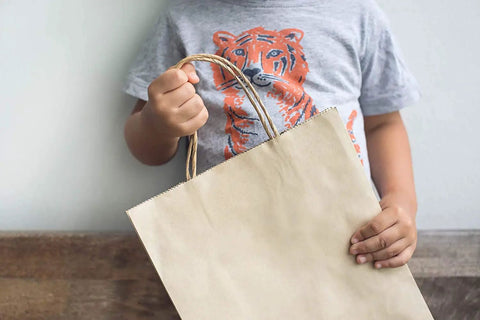 Child holding Bulk 500 Pack Heavy Duty Kraft Paper Bags 10x13 Inches With Handles 10x5x13 Inches Brown Gift Shopping Retail Bags