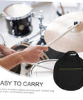 Hands holding a drumstick near a Rock Solid Marching Cymbal Bag With Sickly Padded Cushioning Spacious Zippered Pockets For Drums Sticks And Sheet Music Heavy Duty Oxford Fabric Built For Travel.