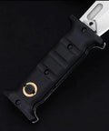 Close-up of folding hunting knife with D2 steel blade and non-slip G10 handle for outdoor tactical camping and survival use.