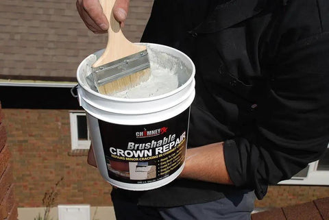Person applying Brushable Chimney Crown Repair Elastomeric Waterproof Coating for Crowns and Masonry Flexible Sealant Prevents Leaks Cracks Quick Setting Long Lasting Protection 2 Gallon on a rooftop