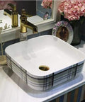 Premium Ceramic Vessel Sink, Snazzy Square Countertop Basin on marble countertop with gold faucet and decor.