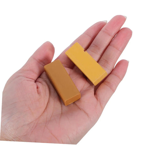 Hand holding two wax sticks from Eight Pieces Furniture Wax Crayons For Wood Floors And Furniture Repair Quick Scratch Fix Chip Holes.