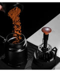 Smooth Operator Espresso Rotary WDT Tool And Coffee Stirrer With Built In Dosing Funnel Stand For Even Powder Distribution and Knockout Barista Shots At 54mm with coffee grounds being poured.