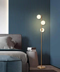 Three Globe Brushed Brass Floor Lamp, Modern LED Standing Light For Living Room, Bedroom, And Office next to bed