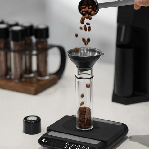 Single Dose Coffee Storage Tubes With One Way Exhaust Valve 8 Piece Set Espresso Dosing Jars and Walnut Holder filled with coffee beans.