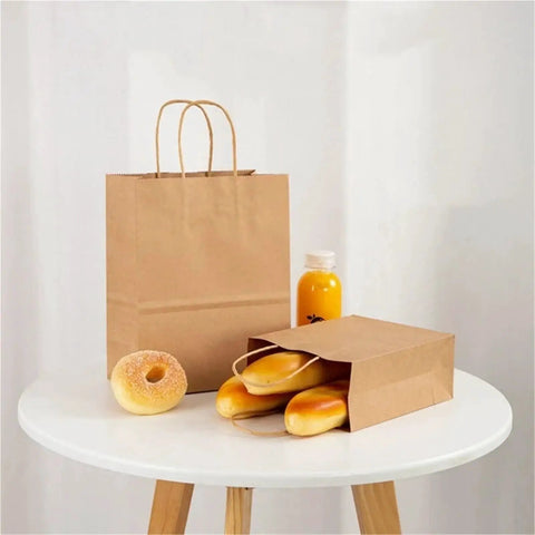 Thickened Kraft Paper Shopping Bags 60 Pack 26x12x31 Cm on a table with bread and juice, durable brown paper bags for various uses.