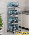 Hella Sturdy 5 Tier Metal Storage Rack With Swivel Wheels For Kitchen Or Pantry Heavy Duty Adjustable Shelving Unit holding water jugs.