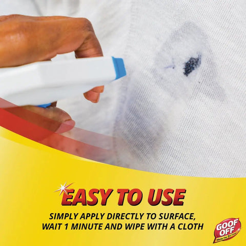 Close-up of Household Spot And Stain Remover being sprayed on a stained white fabric surface.